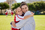 Portrait of mother and girl hug at soccer training, bonding and embracing on a field. Sport, fitness and support by parent for child hobby and passion, enjoying morning activity  and football outdoor