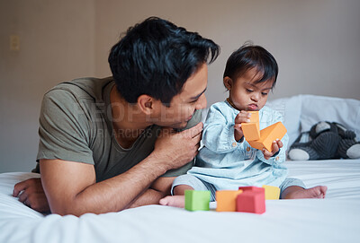 Buy stock photo Father and down syndrome baby play education game with toys on bed for growth and happy together. Man smile in bedroom with toddler boy, learning color and development in home with building blocks