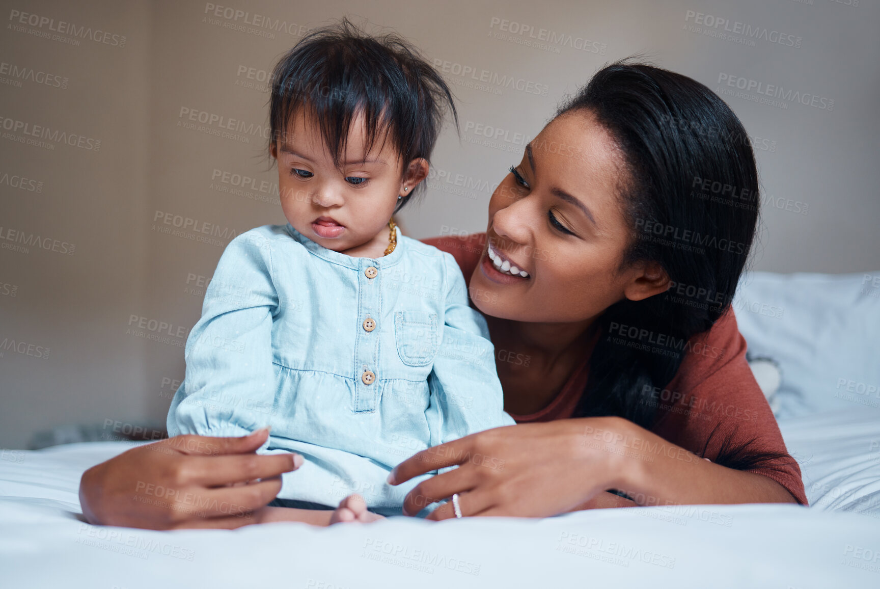 Buy stock photo Love, mother and down syndrome baby in bedroom together to relax and bond in Puerto Rico house. Care, love and support of mom embracing child with mental disability on bed in happy family home.