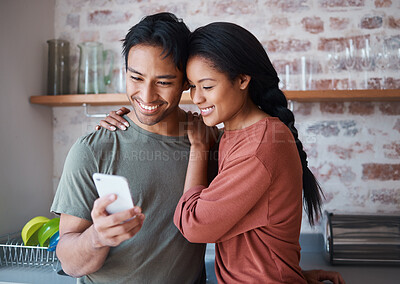 Buy stock photo Asian couple, phone or bonding hug in house or home kitchen with communication technology, social media app or internet news. Smile, happy and love man and relax woman with mobile for zoom video call