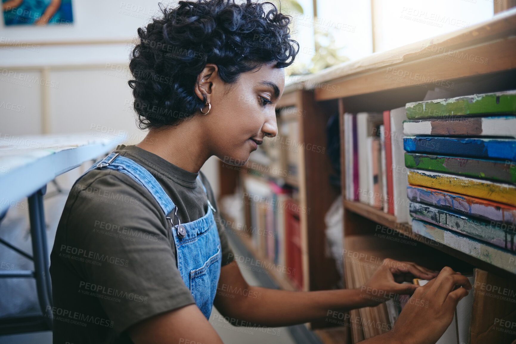 Buy stock photo Books, creative and Indian student search bookshelf for reading poetry information, learning or knowledge in a work studio or classroom. Teenager woman with history, philosophy or dictionary research