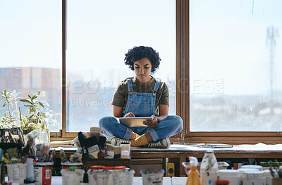 Buy stock photo Creative, art and woman on digital tablet sitting by the window in her studio or workshop. Creativity, artistic and hipster girl artist doing research on the internet with mobile device in workspace.