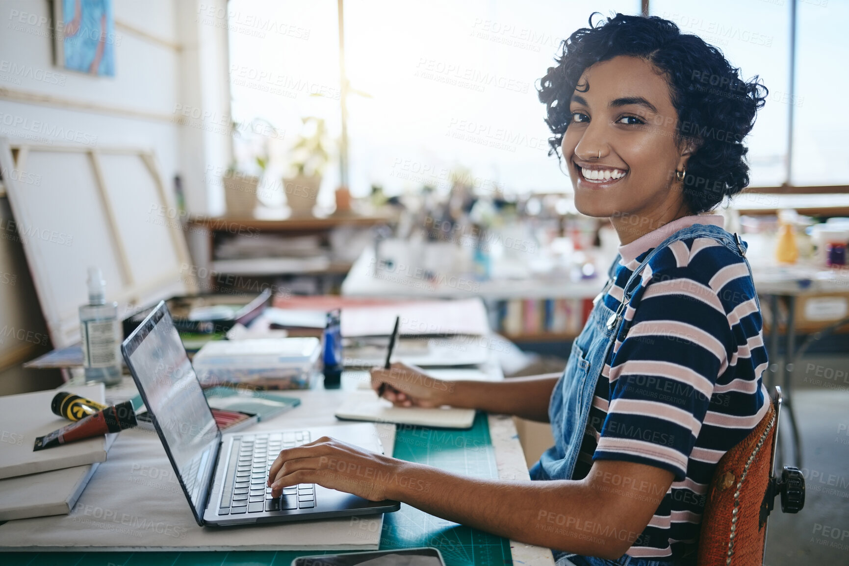 Buy stock photo Creative black woman, smile and laptop working in art studio, workshop or design startup with notebook. Portrait of a happy African American female freelancer, designer or artist at work on computer