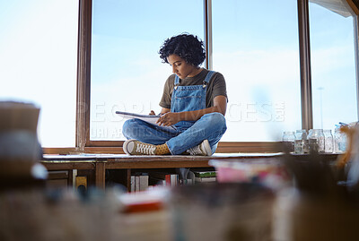 Buy stock photo Focused woman, student and drawing by window in creative studio or workshop with a book indoors. Young female designer or artist sketching, learning and sitting in a art shop or school in Brazil