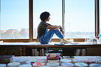 Art, creative and woman painter thinking of idea for painting by a table nd window in a studio. Girl designer or artist working on drawing and creativity at a workshop for motivation and inspiration