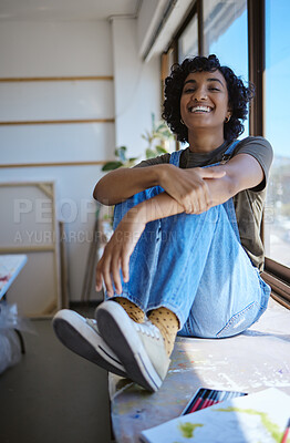 Buy stock photo Young woman, artist and by table with window relax, happy and smile in workshop or studio. Creative black female, lady or designer student content with work and calm in workspace and gallery
