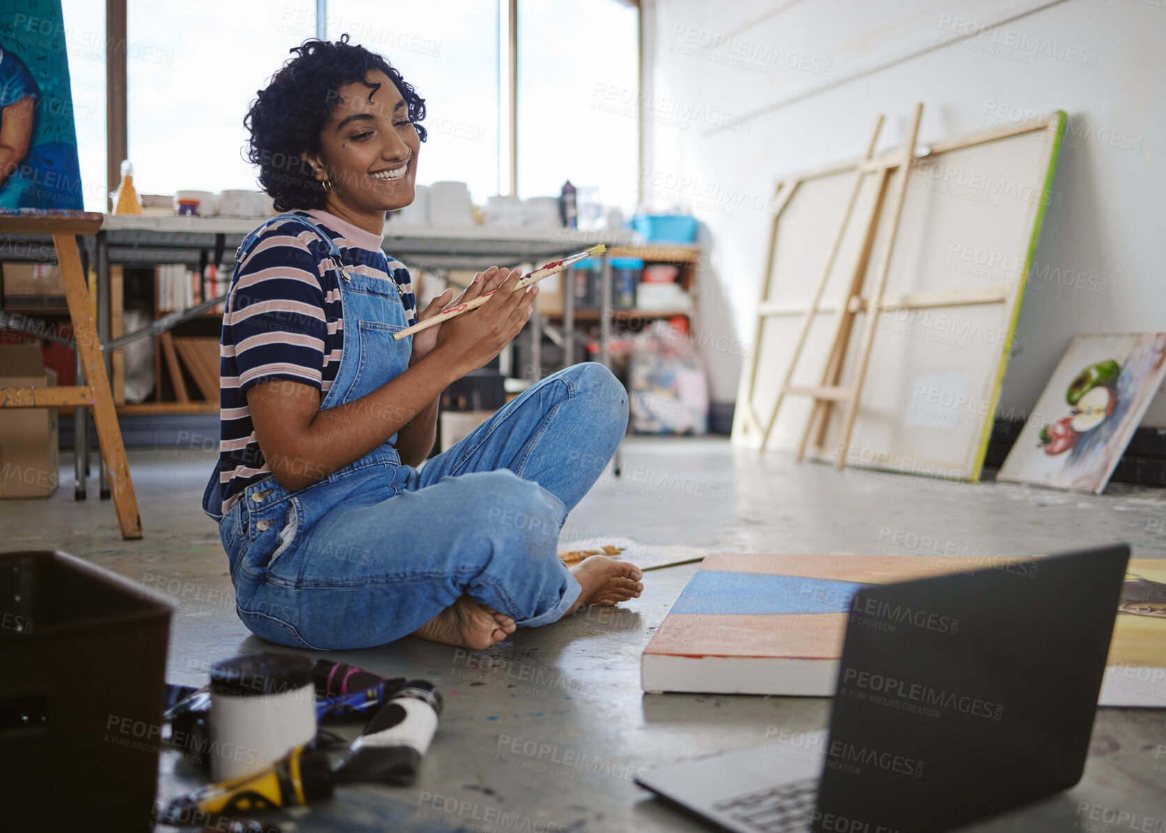 Buy stock photo Paint, art and laptop with a woman painter following an internet class in her creative workshop or studio. Computer, painting and artistic with a female artist sitting on the floor of her gallery