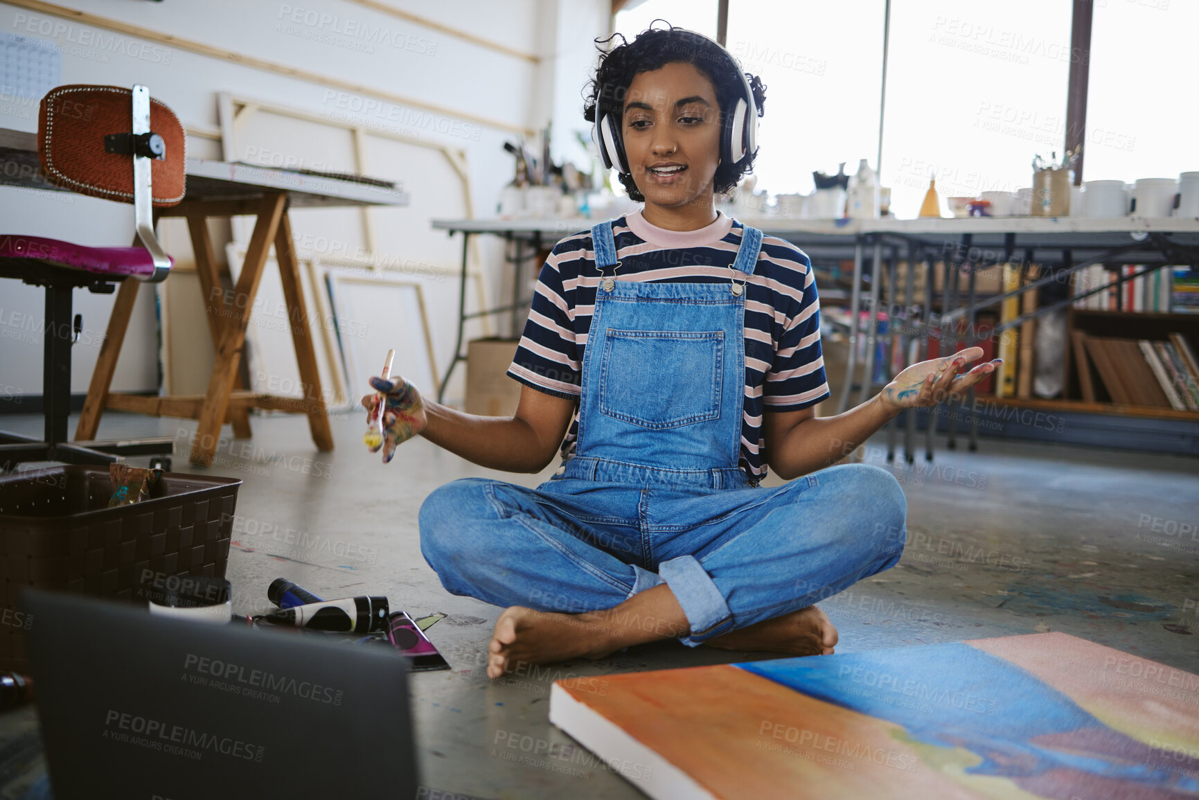 Buy stock photo Painter girl and laptop video call with headphones for concentration and focus in painting class. Artistic Indian woman learning artist paint brush tutorial and technique online in workshop.

