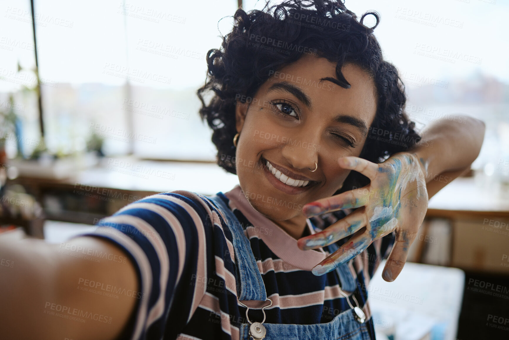 Buy stock photo Woman artist taking selfie, painter in her art workshop and happy with a hand full of paint. Young, Indian professional creative smile in self portrait, having fun painting and working. 