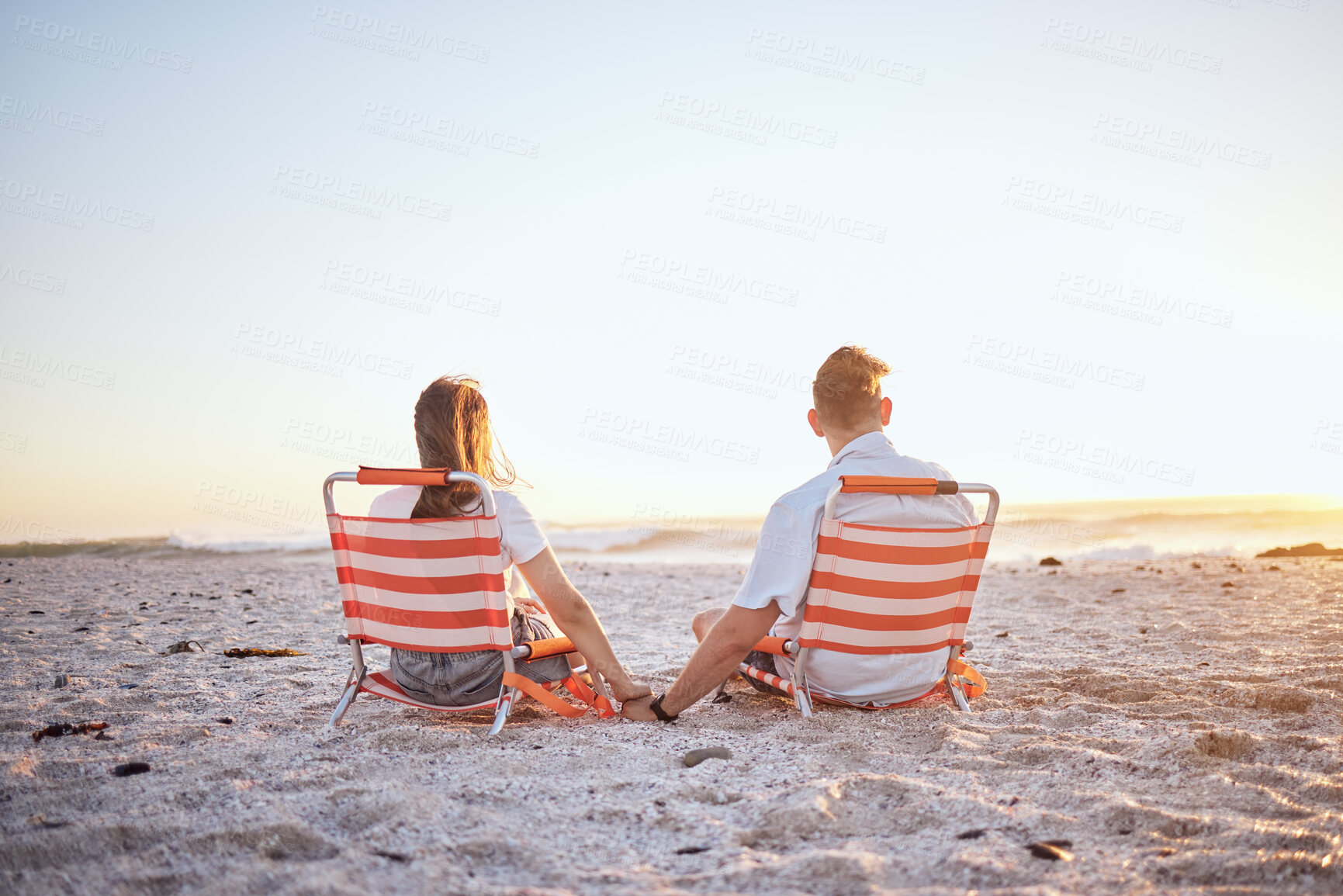 Buy stock photo Love, couple and holding hands while on beach with sunset, ocean and relax while on sand, holiday and vacation. Romance, man and woman have fun together, 
and enjoy seaside getaway for anniversary.