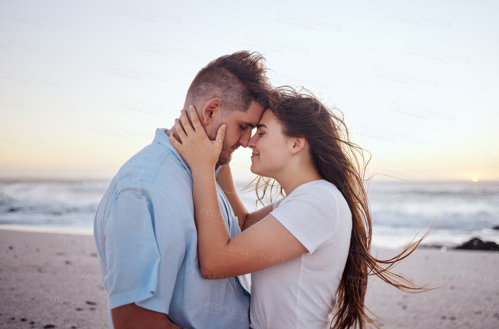 Buy stock photo Couple, love and beach at sunset with face in hands for travel, vacation or holiday by the sea. Man, woman and ocean show happiness, smile and care together by waves, sand and summer sunshine in Bali