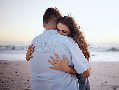 Buy stock photo Love, hug and romance with a couple on the beach during a date on the sand by the sea or ocean at sunset. Summer, nature and travel with a young man and woman hugging on the coast while dating