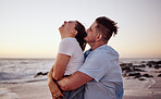 Sunset, love and young couple on the beach bonding, laughing and enjoying their honeymoon holiday. Happy, smile and man embracing his woman from behind while on a romantic vacation in Miami Florida.