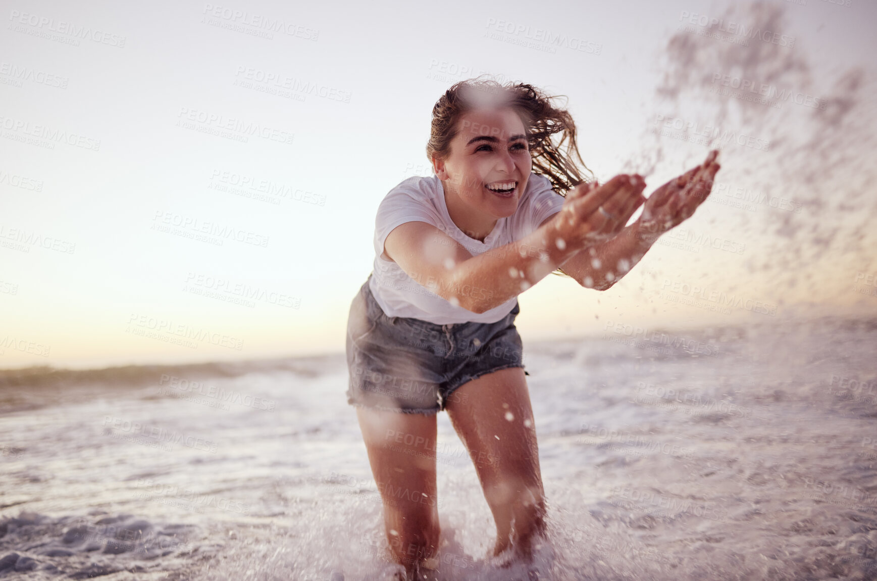 Buy stock photo Splash, ocean and woman at the beach in the water, enjoying the waves at sunset. Summer adventure, holiday and happy girl having fun on vacation. Freedom, joy and playful female splashing in the sea