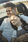 Roadtrip, travel and couple in a car on the road together, taking a drive. Love, dating and happy couple in motor vehicle hugging, laughing and smile on their face. Holiday, vacation and adventure 