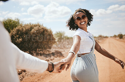 Buy stock photo Couple, walking and nature with a black woman and man outdoor holding hands on a sand road in a dessert together. Travel, love and romance with a female and male on a date during summer vacation