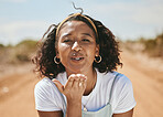 Happy woman, blowing kiss and portrait for love emoji, relax and flirting outdoors in Colombia. Young, smile and freedom gen z girl with expression of hand kisses, joy and summer happiness in nature