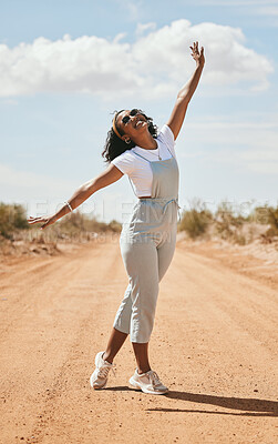 Buy stock photo Freedom, nature and travel with a black woman on a sand road in the dessert during a summer holiday. Happy, vacation and free with an attractive young female posing outdoor with a carefree attitude