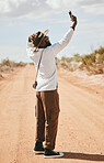 Selfie, black man and outdoor with summer look travelling on dirt road being relax, cool or countryside on safari or holiday. Smartphone, African American male and vacation adventure, relax or happy.
