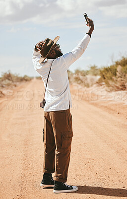 Buy stock photo Selfie, black man and outdoor with summer look travelling on dirt road being relax, cool or countryside on safari or holiday. Smartphone, African American male and vacation adventure, relax or happy.