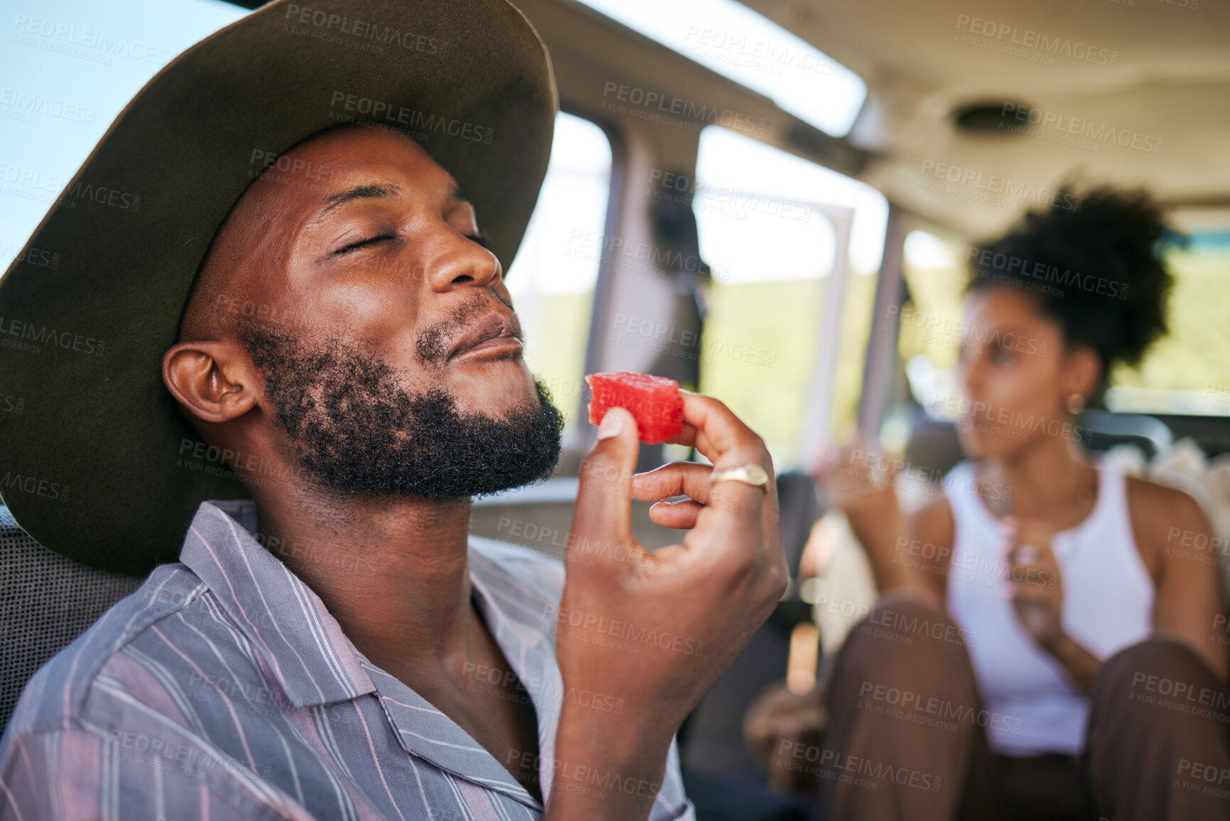 Buy stock photo Black man, eating watermelon and summer fruit on safari game drive in sustainability nature or environment landscape travel. Smile, happy tourist or couple and diet health food in Kenya national park