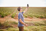 Nature, agriculture and a man taking selfie with phone on farm on road trip stop. Travel, view and vineyard, young traveler with smartphone in field. Gps, wifi or 5g network on mobile in grass field.