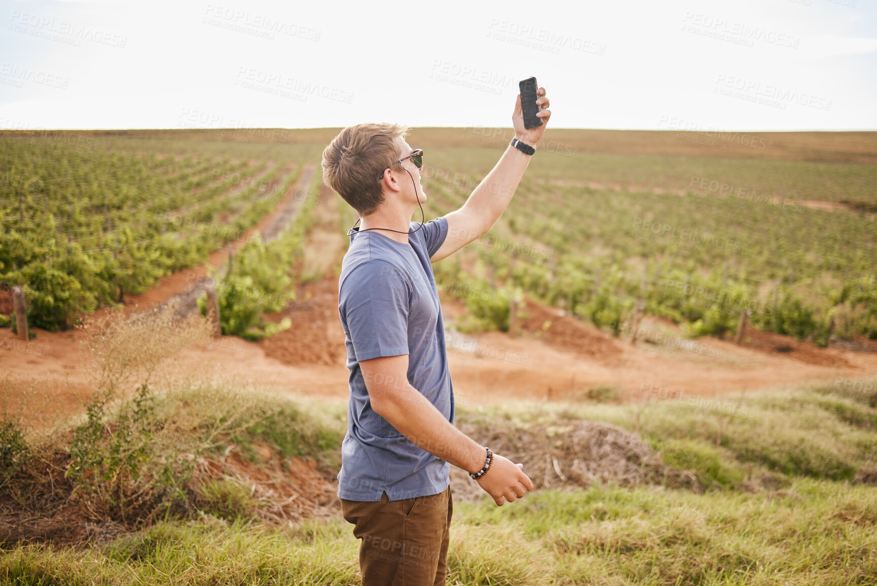 Buy stock photo Nature, phone and a man with lost signal in field on farm road trip. Travel, view and vineyard, young traveler with smartphone in agriculture. Gps, wifi or 5g network search on mobile in grass field.