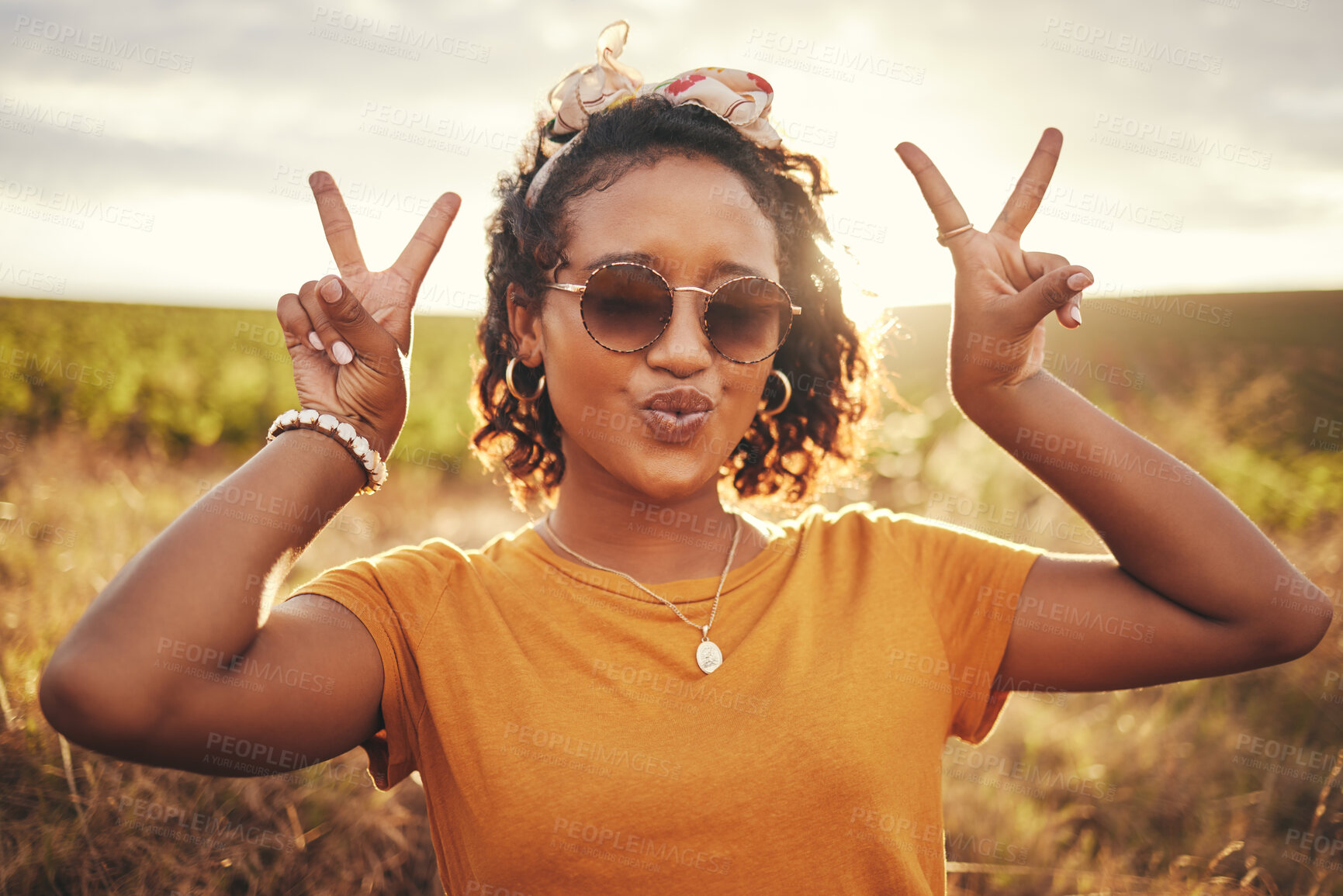 Buy stock photo Hands, peace and nature with a woman in a field of green grass with a blue sky or sunset background for travel. Summer, vacation and freedom with a female posing for a photograph with a hand sign