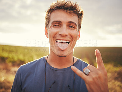 Buy stock photo Man, hands and portrait of rock sign for travel tour or vacation in the countryside and nature outdoors. Happy, excited young male traveler, rocker or musician with hand gesture and tongue out