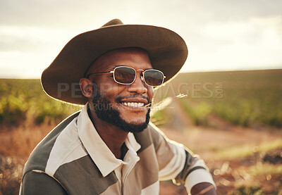 Buy stock photo Farm, agriculture and sustainability with a black man farmer outdoor on a grass field or land for organic farming. Agricultural, sustainable and green with a male wearing a hat and sunglasses outside