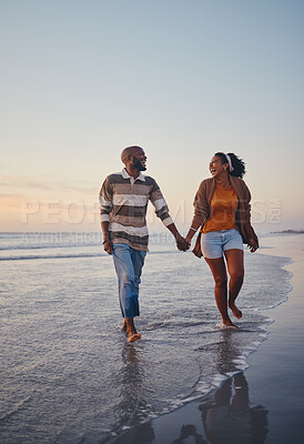 Buy stock photo Travel, beach and couple walking in the sea, laughing and bonding on an ocean trip. Freedom, love and romance with black woman and man enjoy conversation and funny joke while holding hands in water