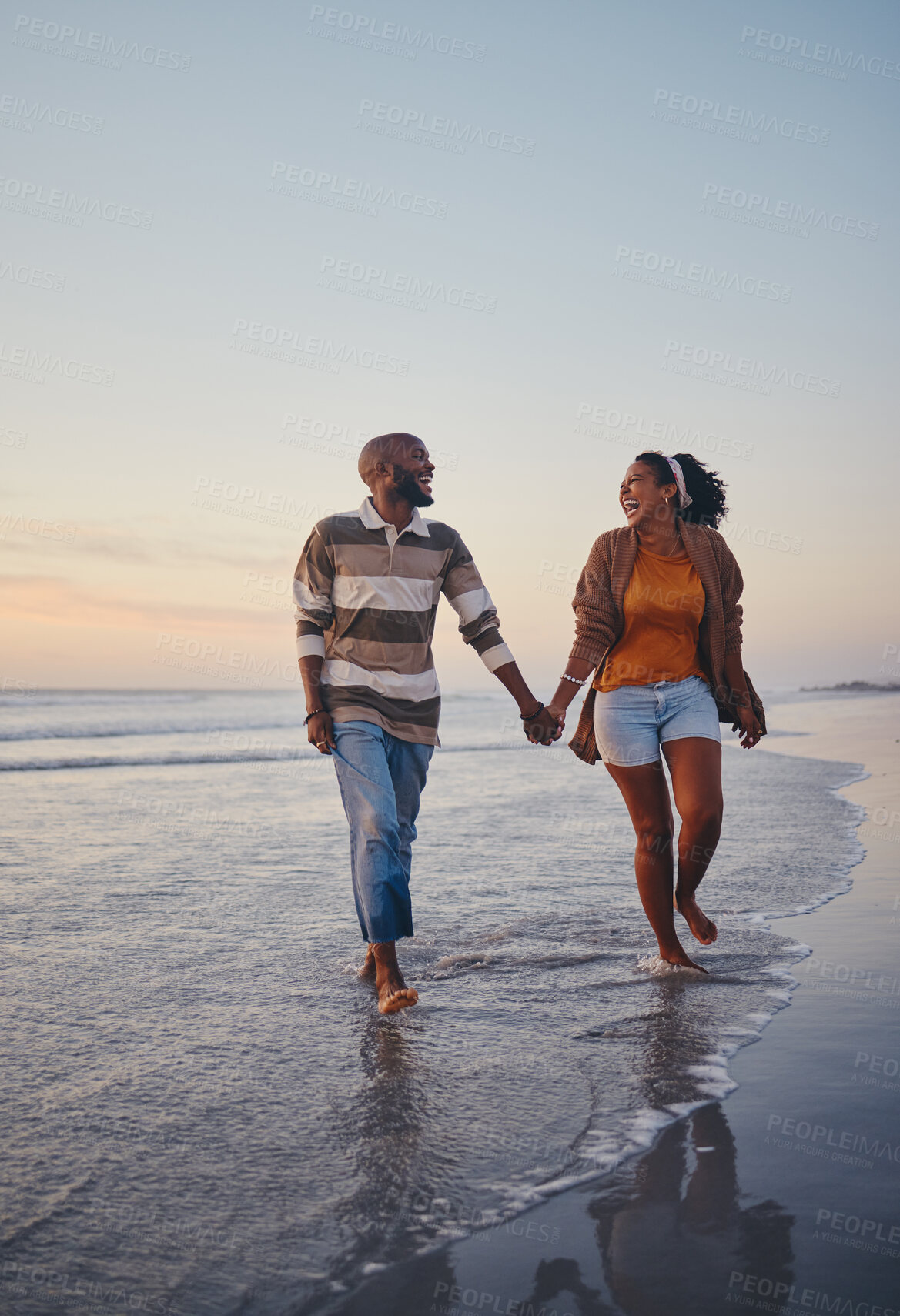 Buy stock photo Travel, beach and couple walking in the sea, laughing and bonding on an ocean trip. Freedom, love and romance with black woman and man enjoy conversation and funny joke while holding hands in water