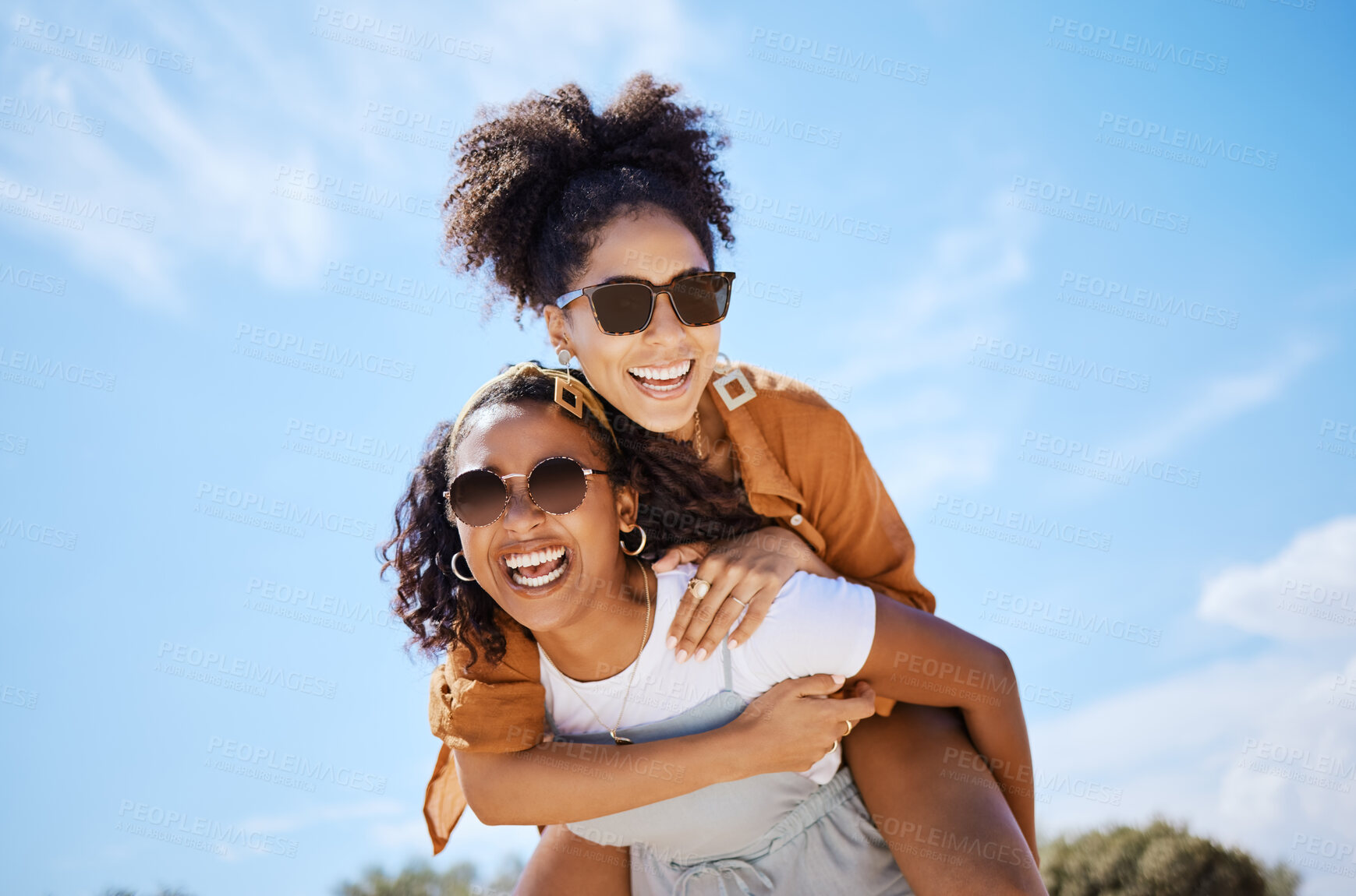 Buy stock photo Summer, friends and freedom with women and piggy back against the blue sky for hug, lifestyle and happy on Puerto rico holiday. Youth, crazy and friend with girl on vacation with glasses and a smile