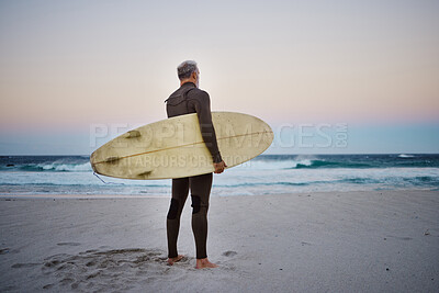 Buy stock photo Surfer, surfboard and senior man on beach at sea waves in during sunset during summer vacation in Hawaii. Professional male athlete rest after training or practice surfing sport outdoor at the ocean