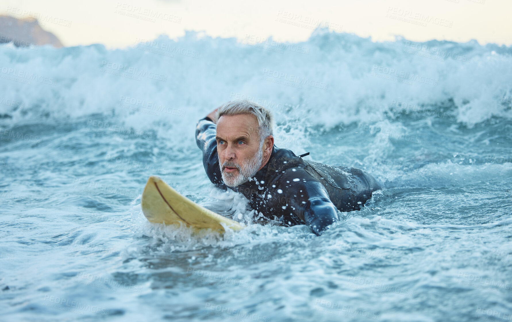 Buy stock photo Beach, surfer and old man on surfboard swimming in nature enjoying dangerous water sports and retirement. Training, fitness and senior athlete surfing on the sea waves with freedom in Los Angeles
