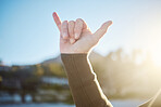 Shaka, hand sign and man outdoor in nature on an adventure or holiday in summer in hawaii. Chill out gesture, friendly and guy with surf culture on tropical vacation for fun, leisure and freedom.