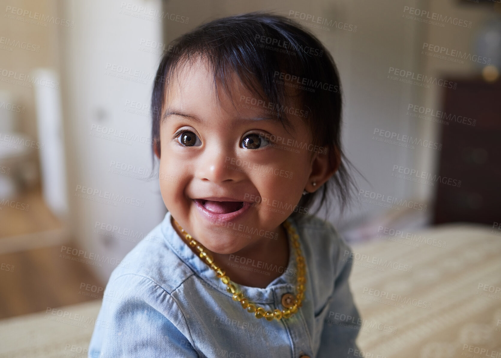 Buy stock photo Baby, girl and cute with a down syndrome little child on a bed in the bedroom of her home alone. Children, kids and face with a sweet female kid looking innocent, pure and carefree in her house