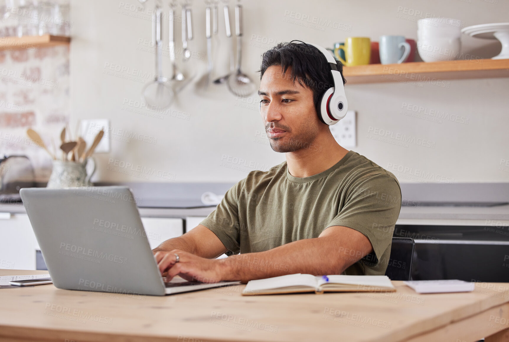 Buy stock photo Laptop, kitchen and student with music headphones to listen to rock song while working on research project. Young gen z man relax at home while streaming audio podcast or radio for peace and wellness