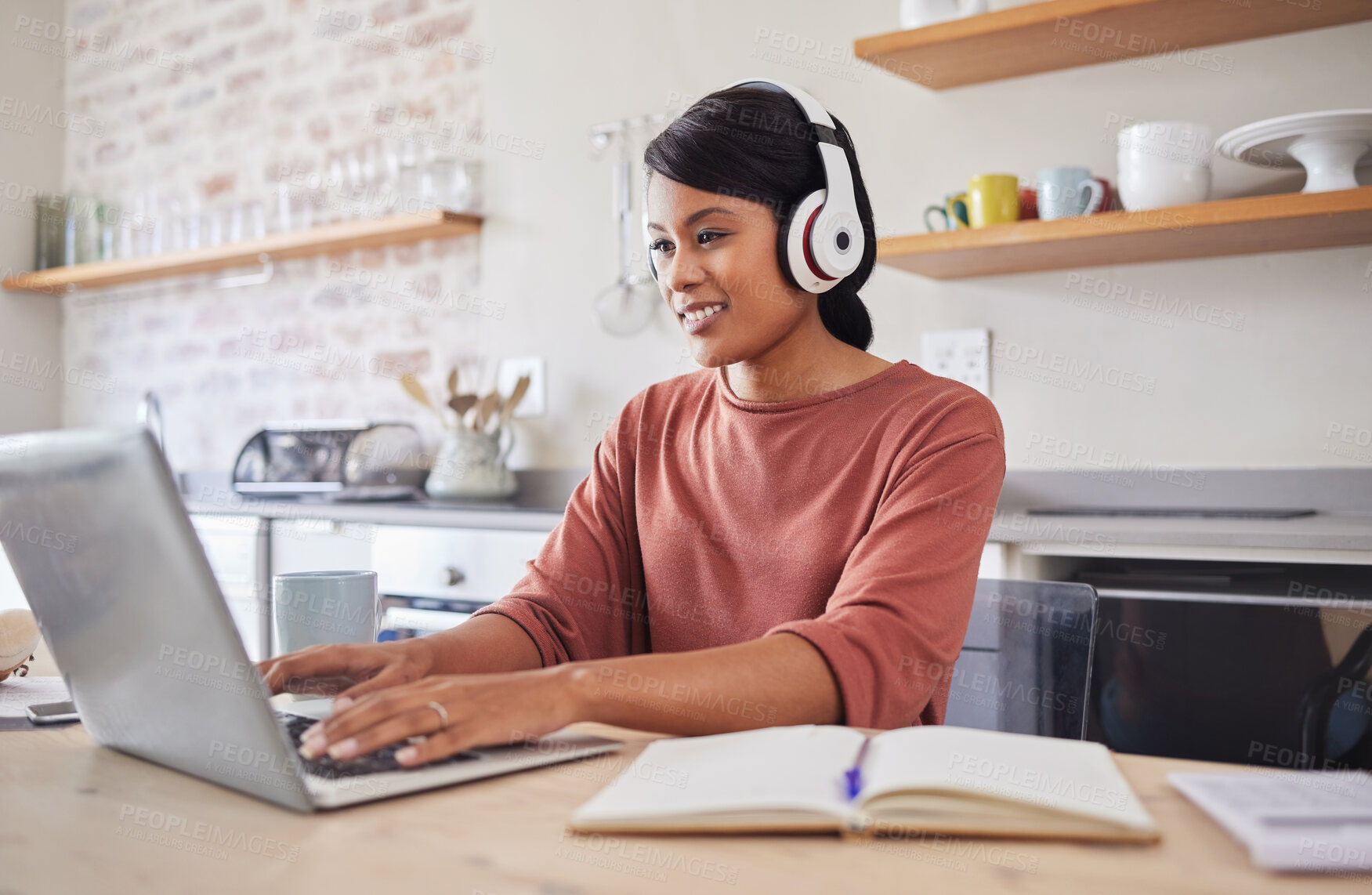 Buy stock photo Email, music and black woman typing on the internet on a laptop while working at a table in her house. Remote African worker planning on web with technology while listening to a podcast in her home