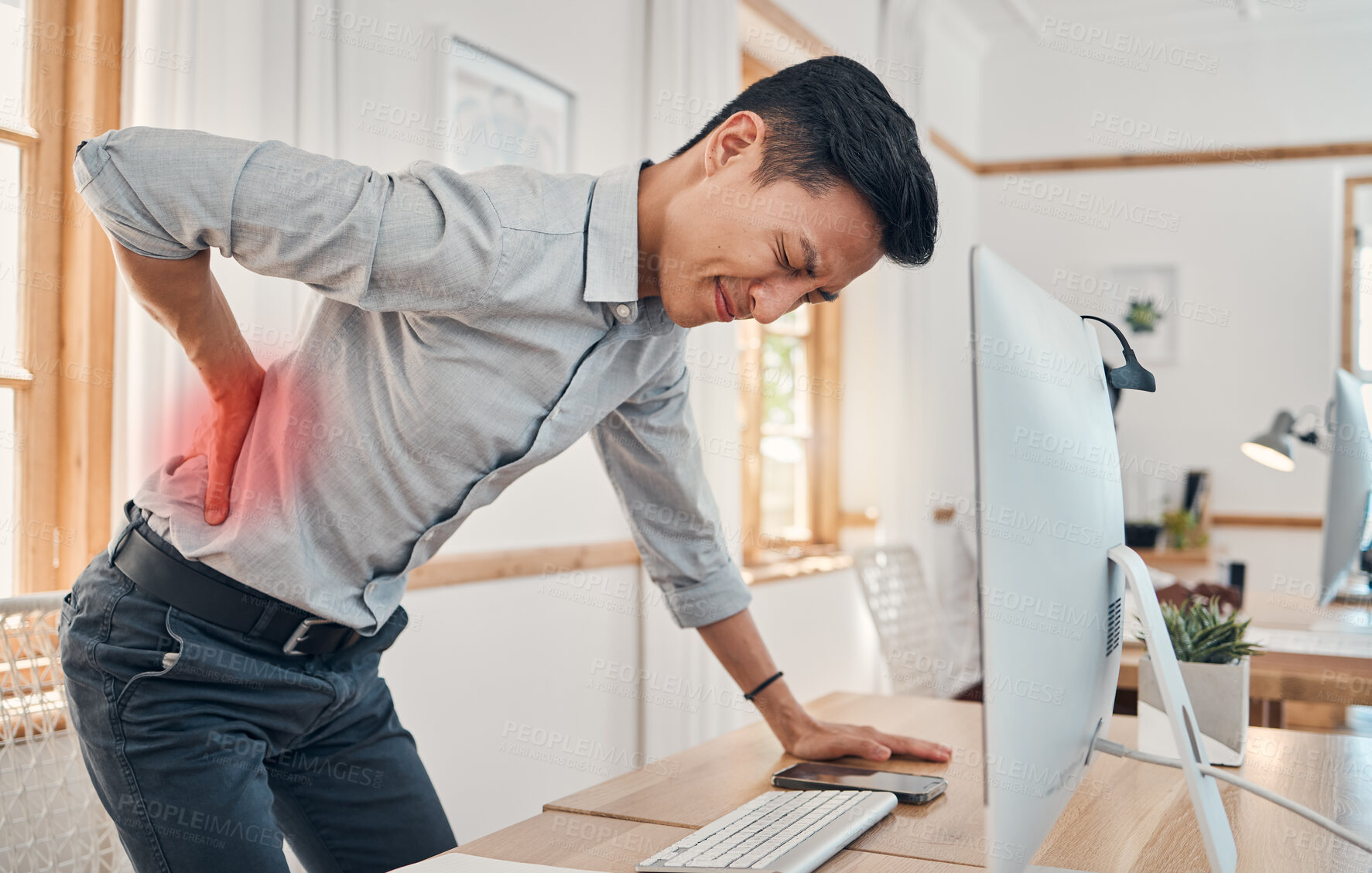 Buy stock photo Businessman with back pain, muscle injury and burnout at office desk. Young frustrated man suffering from spinal inflammation, body discomfort or strain and healthcare stress emergency






