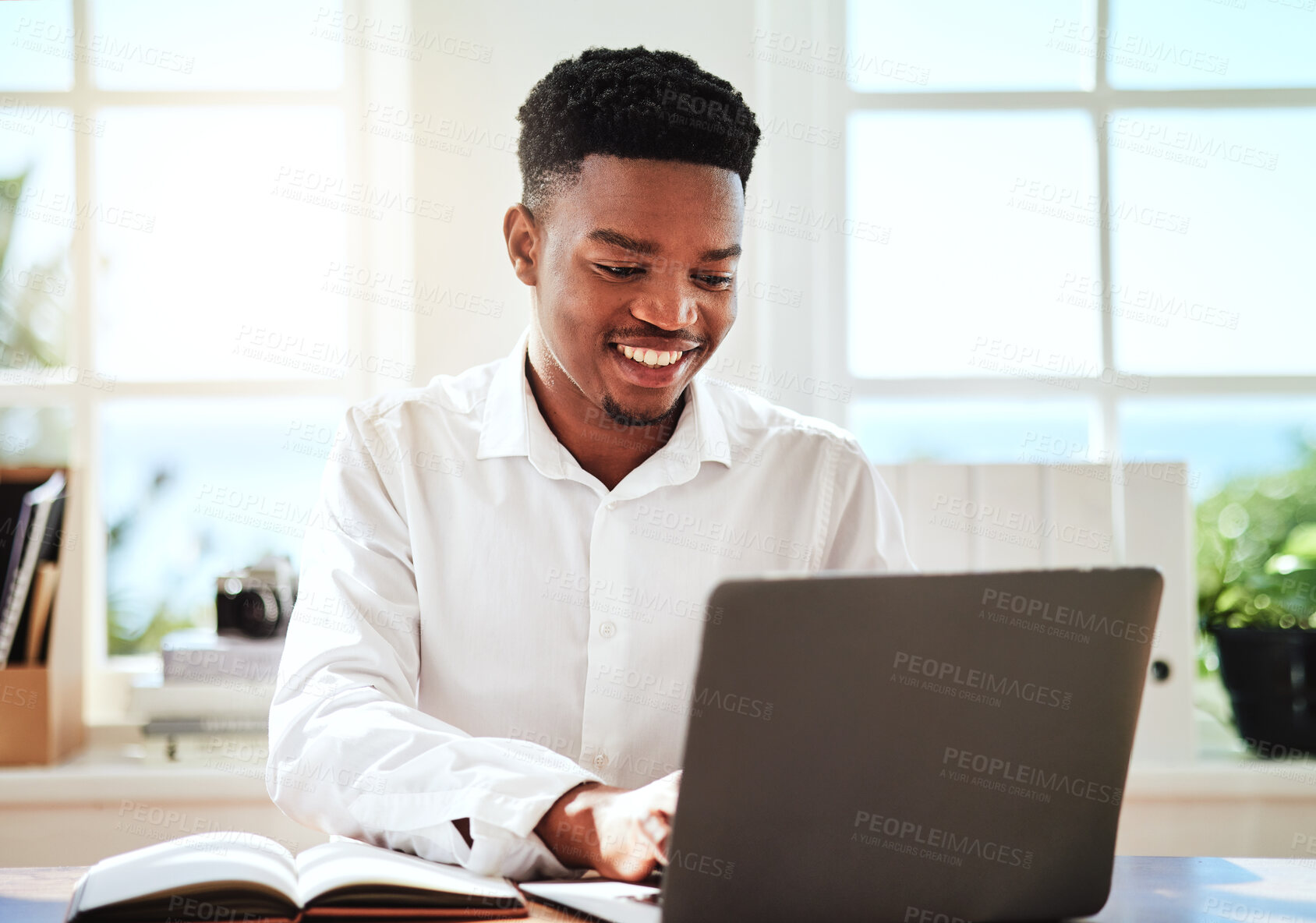 Buy stock photo Laptop, typing and schedule with a black man graphic designer working online with his computer and notebook. Email, creative and internet with a young male employee at work on a creative project