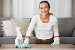 Woman cleaning her home, table and living room with chemical disinfectant soap to clean the house of dirt or germs. Mom doing housekeeping with a smile, family room is hygienic and healthy for kids  