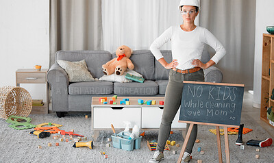 Buy stock photo Cleaning, living room and blackboard with a woman mother in her home to clean up children toys off of the floor. Mom, cleaner and mess with a strict female in messy lounge with a helmet and goggles
