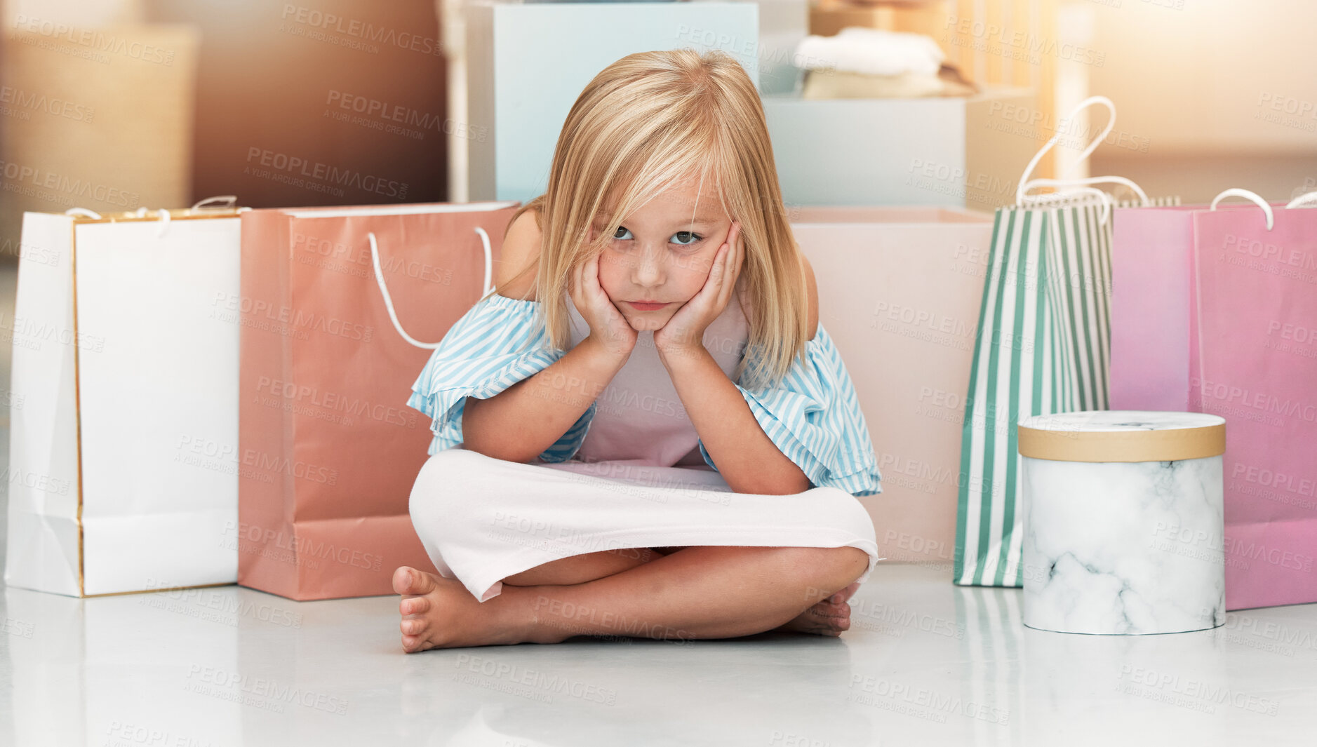 Buy stock photo Bored child, fashion and shopping bags waiting on floor in kids clothing shop, store or boutique with cute girl sitting looking upset. Portrait of kid shopper or customer with sale purchase packages