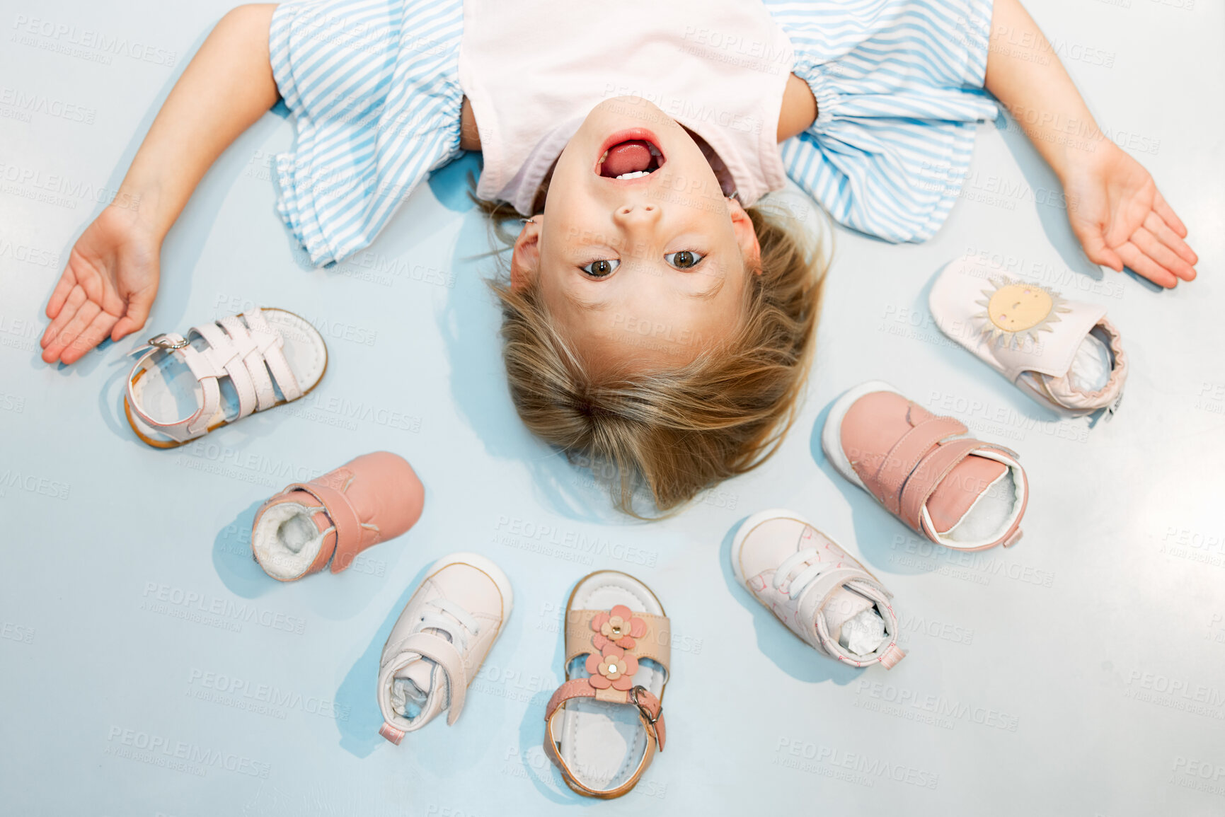 Buy stock photo Child, shoes and head above floor with smile on face against blue backdrop. Girl, happy and sandal in mockup excited with happiness, color and summer fashion against studio background in Sweden