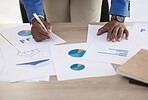 Businessman, paper and data on chart, analytics and graph for analytics in finance business on desk. Black man, working and writing on document for financial strategy, planning and economy of market