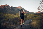 Runner, fitness on mountains and man running in nature for outdoor workout, wellness and healthy lifestyle with energy, goals and motivation. Sports person exercise or training run on hiking road