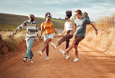 Buy stock photo Travel, friends holding hands and dance in nature, outdoors or countryside on vacation. Happy, diversity and group smile, spending time together and dancing, celebration and having fun on sandy road.