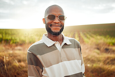 Buy stock photo Fashion, farm and agriculture with a black man farmer outdoor in the summer sun in sunglasses. Sustainability, farming and style with a handsome young male outside on a green meadow or field of grass