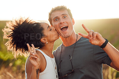 Buy stock photo Funny, kiss and couple bonding during vacation on a farm with peace sign. Happy interracial husband and wife standing close together on vineyard in summer. Young husband and wife feeling in love 

